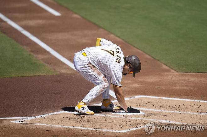 홈에 들어오고 다음 타자를 위해 홈플레이트를 닦는 김하성 [AFP/게티이미지=연합뉴스]