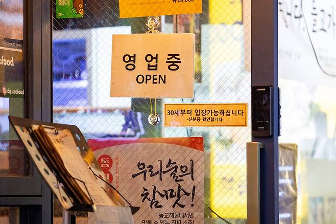 서울 동교동 한 술집 출입문에 ‘30대부터 입장 가능하십니다’라는 공지가 붙어 있다. 20대의 핫플레이스로 꼽히는 홍대 인근에서 인기를 끈 이 술집은 최근 2호점을 열었다. /이건송 영상미디어 기자