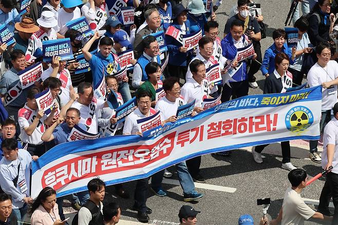 8월 25일 이재명 대표를 비롯한 더불어민주당 의원들이 서울 종로구 광화문 광장에서 후쿠시마 원전 오염수 투기 중단을 촉구하며 용산 대통령실 방향으로 행진하고 있다. 연합뉴스