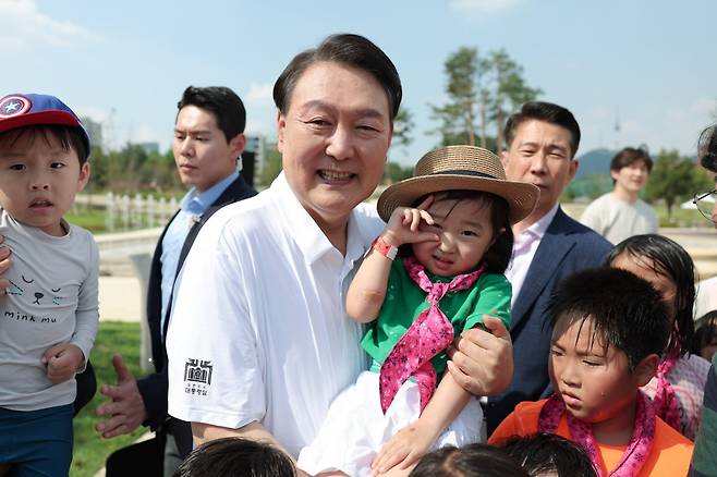 윤석열 대통령이 26일 서울 용산어린이정원 내 조성된 분수정원에서 열린 다둥이가족 초청행사에 깜짝 방문, 어린이들과 기념사진을 찍고 있다. /사진=연합뉴스