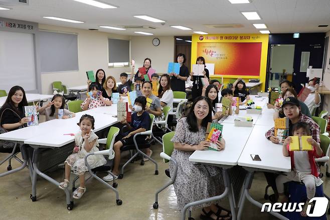 다문화 가족들이 26일 수원시자원봉사센터 강당에서 직접 만든 '한지 북아트'를 들고 기념 촬영을 하고 있다.(수원시 제공)