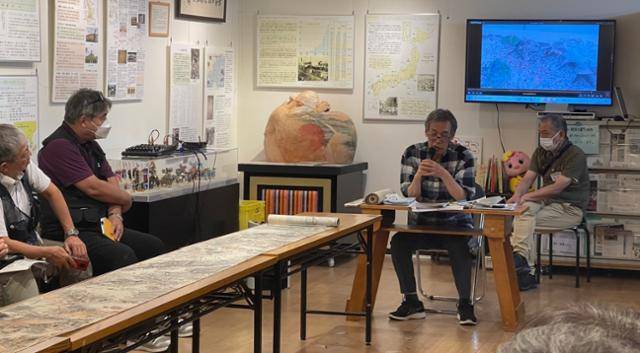 간토대지진 조선인 학살 100년을 맞아 당시를 묘사한 두루마리 그림을 전시하고 있는 일본 도쿄 신주쿠구 고려박물관에서 26일 이 그림을 발굴한 아라이 가쓰히로(왼쪽 두 번째) 전 관장이 강연을 하고 있다. 앞에 두루마리 그림이 보인다. 도쿄=최진주 특파원