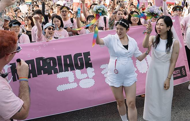 ‘레즈비언 유부녀’ 김규진씨와 김세연씨가 1일 서울 을지로 일대에서 열린 제 24회 서울퀴어문화축제에 참석해 결혼식 퍼포먼스를 진행하고 있다. 국제 엠네스티 제공