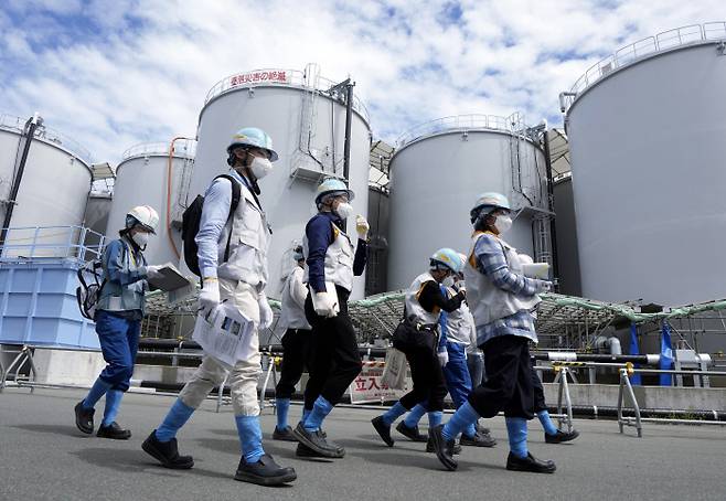 현장 공개 외국 기자들이 27일 일본 후쿠시마 제1원자력발전소를 운영하는 도쿄전력 관계자의 안내로 오염수가 보관된 탱크 주변을 둘러보고 있다. EPA연합뉴스
