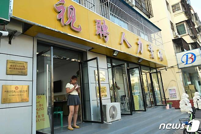 (AFP=뉴스1) 권영미 기자 = 지난 6월 청년실업률이 21.3%를 기록한 중국이 8월부터는 전국 청년 및 기타 연령대의 실업률 조사를 중단하기로 했다. 사진은 한 여성이 베이징의 한 구직 사무실 입구에 서 있는 모습.2023.08.15.  ⓒ AFP=뉴스1  Copyright (C) 뉴스1. All rights reserved. 무단 전재 및 재배포 금지.