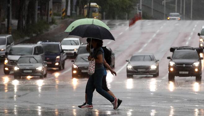 24일 오후 대구 북구 관음동 칠곡나들목 주변에 많은 비가 내리는 가운데 우산을 쓴 시민들이 발걸음을 재촉하고 있다. /뉴스1