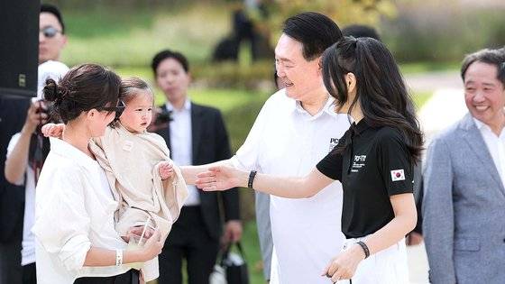 윤석열 대통령과 김건희 여사가 지난 26일 서울 용산 어린이정원 내 분수정원에서 열린 다둥이가족 초청 행사에 깜짝 방문해 어린이와 인사를 나누고 있다. 사진 대통령실