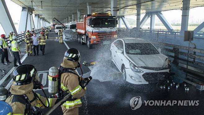 '추돌사고 현장 화재 대응은 이렇게' (영종도=연합뉴스) 김상연 기자 = 13일 오후 인천시 중구 신공항하이웨이 영종방면 영종대교 하부에서 열린 '2023 재난대응 안전한국훈련'에서 안개상황을 가정해 발생한 추돌사고 현장에 급파된 소방대원이 화재 진압을 시도하고 있다. 2023.06.13 [공동취재] goodluck@yna.co.kr