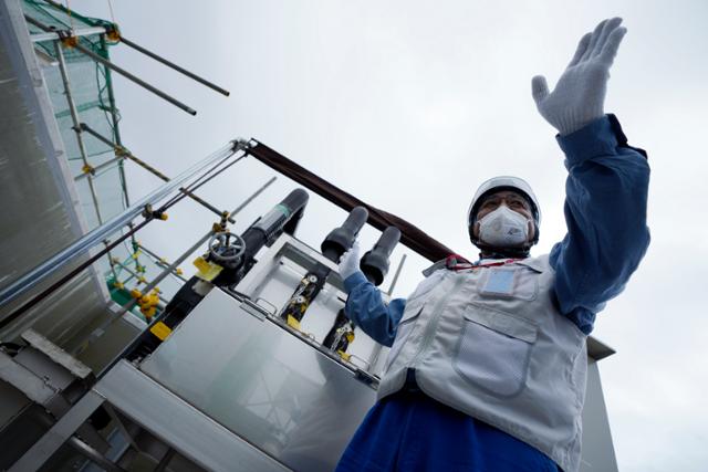 일본 도쿄전력 관계자가 27일 후쿠시마현 후타마에 있는 후쿠시마 제1원자력발전소에서 희석을 완료한 오염수의 샘플을 채취하는 기계를 취재진에게 설명하고 있다. 연합뉴스