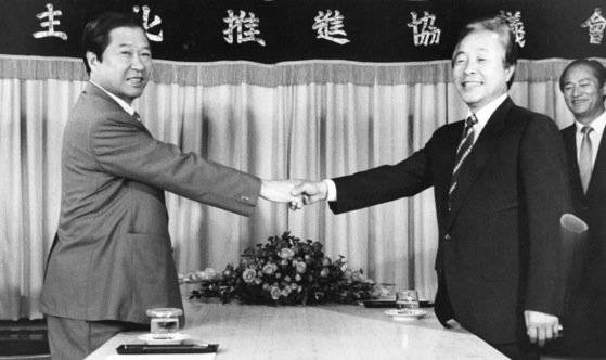 1987년 8월 6일 통일민주당(민주당)에 입당하기로 결정한 뒤 김영삼 총재(오른쪽)와 악수하고 있다. 이틀 뒤 민주당에 입당했으나 대선 후보를 두고 갈등을 벌이다 탈당했고, 11월 12일 평화민주당(평민당)을 창당했다. [중앙포토]
