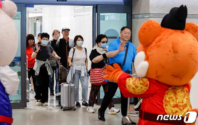 (인천공항=뉴스1) 박정호 기자 = 중국인 단체 관광객들이 지난 24일 오후 인천국제공항을 통해 입국하며 손을 흔들어 인사하고 있다.   한국관광공사는 중국 방한 관광시장 정상화에 따른 중국 방한단체 맞이 환대 행사를 열고 이날 입국한 관광객들에게 꽃다발과 기념품을 전달했다. (공동취재) /뉴스1  Copyright (C) 뉴스1. All rights reserved. 무단 전재 및 재배포 금지.