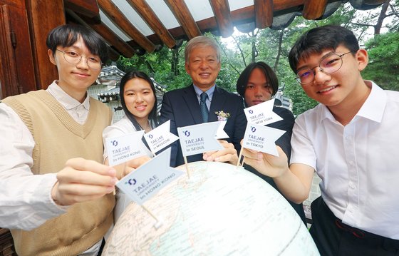 30일 오전 서울 종로구 태재대학교 대학본부에서 열린 1기 신입생 입학식에 앞서 염재호 총장과 학생들이 태재대학교 레지덴셜 캠퍼스가 위치할 도시에 깃발을 꼽으며 포즈를 취하고 있다.   연합뉴스