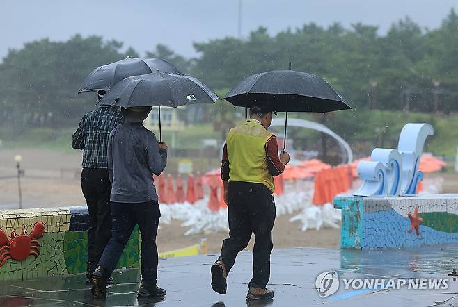 비 내리는 제주 (제주=연합뉴스) 박지호 기자 = 비가 쏟아진 30일 오전 제주시 이호해수욕장에서 우산을 든 이들이 산책하고 있다. 2023.8.30 jihopark@yna.co.kr