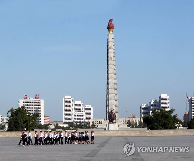 평양 주체사상탑과 앞을 지나가는 평양시민들 [연합뉴스 자료사진]