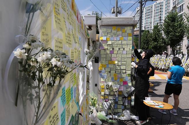 서울 양천구의 한 초등학교 교사가 지난달 31일 숨진 사실이 알려진 뒤인 2일 오후 학교 출입문 주변에서 시민들이 숨진 교사를 추모하는 글을 적어 붙이고 있다. 김정효 기자 hyopd@hani.co.kr