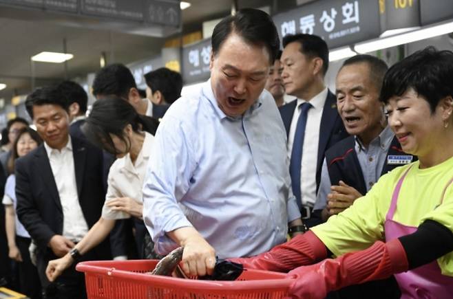 윤석열 대통령이 지난달 27일 부산 중구 자갈치시장에서 장어를 직접 손으로 잡아 보다 장어가 물자 놀란 표정을 짓고 있다. [사진 = 연합뉴스]