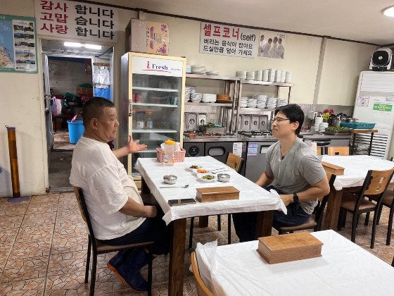 럭키 집을 아치형으로 만들어주신 장본인, 교암숯불고기 남자 사장님(왼쪽). 그와 대화 중인 기자./사진=북끝서점 주인 김상아씨