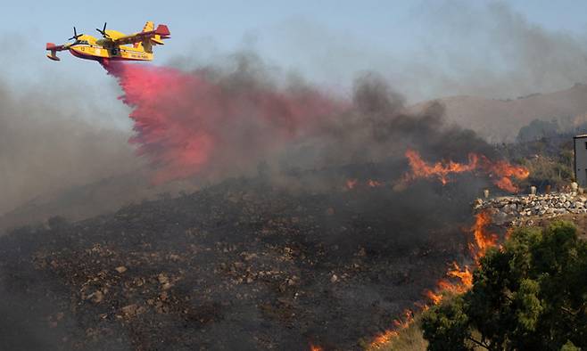 캐나다 소방 헬기가 지난 8월 27일(현지시간) 이탈리아 시칠리아 섬 트라파니 지역의 산불 현장에 난연제(연소 억제 물질)을 살포하고 있다. 트라파니=로이터연합뉴스