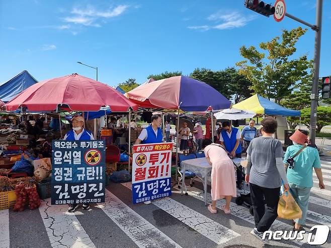 김명진 김대중 재단 광주 서구 지회장(전 청와대 선임행정관)이 지난 1일 광주 서구 치평동 상무 금요시장에서 후쿠시마 핵 오염수 투기 철회 촉구 피켓시위와 서명운동을 벌이고 있다./뉴스1