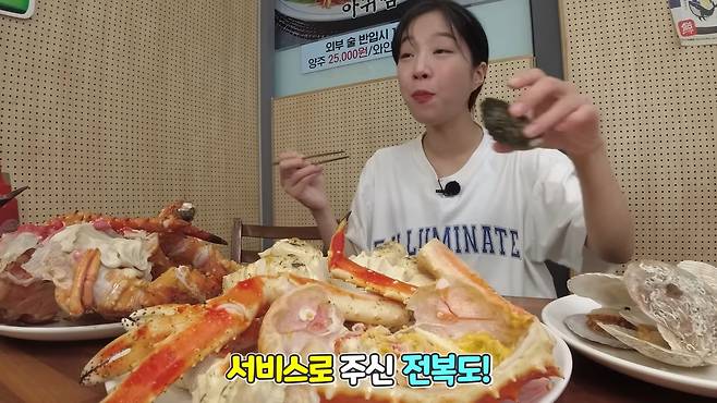 쯔양이 킹크랩과 함께 서비스로 받은 전복을 먹고 있다. /쯔양 유튜브