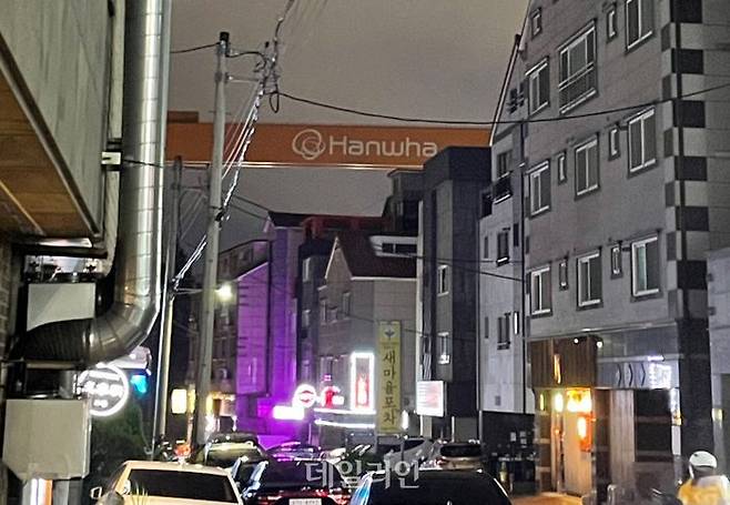 31일 저녁 아주동 먹자골목 너머로 한화오션의 골리앗 크레인이 보인다. ⓒ데일리안 오수진 기자