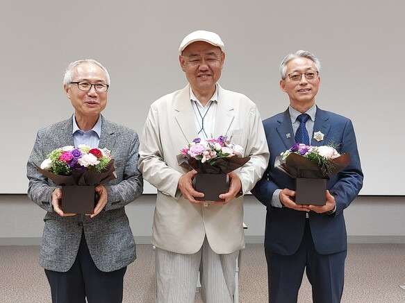 왼쪽부터 이평래 교수, 윤형원 관장, 김장구 교수. 지난달 26일 중앙아시아학회 학술발표회 직후 연단에서 북극성 훈장을 받은 뒤 축하 꽃다발을 안고 있다.