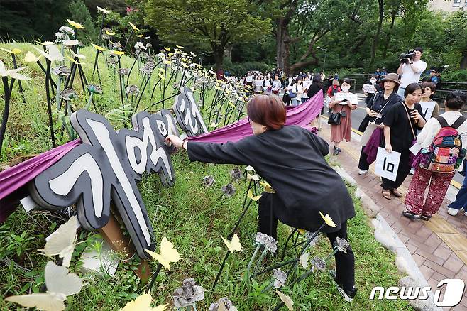 정의기억연대와 여성단체 회원들이 4일 오전 중구 남산 기억의 터에 설치된 원로 민중미술가 임옥상 화백의 조형물 '세상의 배꼽'을 찾아 서울시의 철거 방침을 규탄하며 보라색 천으로 주변을 두르고 있다. 2023.9.4/뉴스1 ⓒ News1 민경석 기자