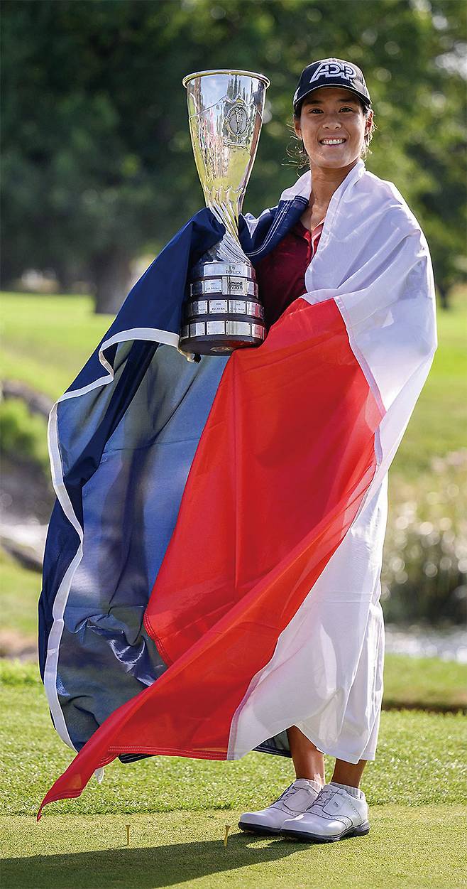 셀린 부티에가 7월 30일 프랑스 알프스 에비앙 레뱅에서 열린 여자 LPGA 메이저 골프 대회인 에비앙챔피언십에서 우승한 후 프랑스 국기를 두른 채 트로피를 들고 포즈를 취하고 있다. 사진 AFP연합