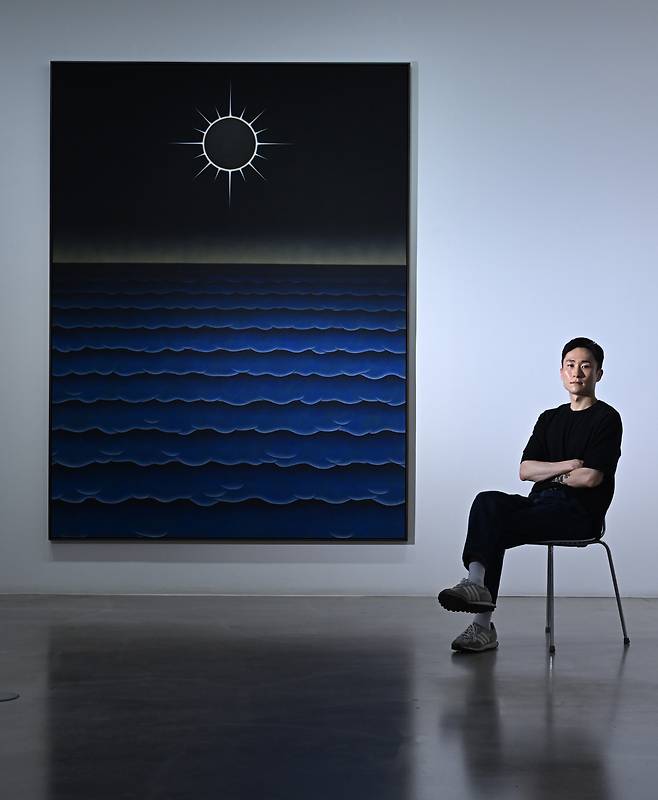 Artist Lee Jae-seok poses for a photo next to his painting "Alignment" at Gallery Baton in Seoul. (Im Se-jun/The Korea Herald)