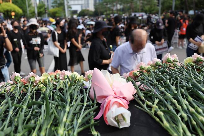 서울 서이초등학교 교사의 49재 추모일인 4일 오후 서울 여의도 국회 앞에서 열린 추모 집회에 앞서 참가자들이 헌화하고 있다. [사진 = 연합뉴스]