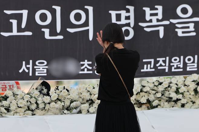 9월3일 서울 양천구의 한 초등학교 정문에 마련된 교사 A씨 추모공간을 방문한 시민이 눈물을 흘리고 있다. 14년 차 초등교사인 A씨는 8월31일 오후 7시께 경기 고양시 덕양구의 한 아파트에서 추락해 숨졌다. ⓒ 연합뉴스