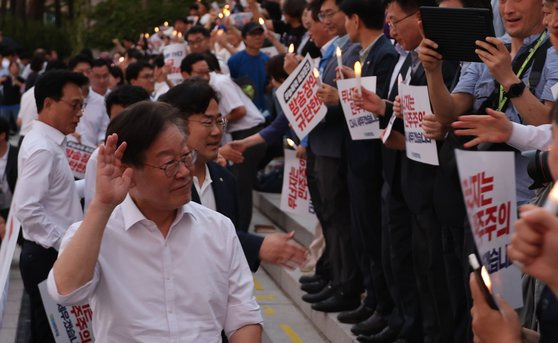 이재명 더불어민주당 대표가 5일 국회 앞 계단에서 민주주의 회복 촛불문화제 참가자들과 인사하고 있다. 연합뉴스