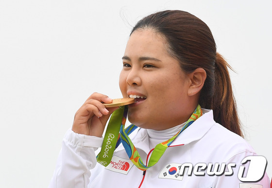 골프 대표팀 박인비가 20일(현지시간) 브라질 리우데자네이루 올림픽 골프 코스에서 열린 2016리우하계올림픽 여자 골프에서 최종합계 16언더파 268타를 기록하며 금메달을 획득했다. 박인비가 시상식에서 금메달을 깨물어보이고 있다.2016.8.21/뉴스1 ⓒ News1 이광호 기자