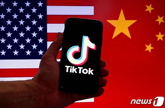 미국과 중국 국기 앞에 애플 아이폰 화면에 표시된 틱톡 로고. 2023.03.16/뉴스1 ⓒ AFP=뉴스1 ⓒ News1 김민수 기자