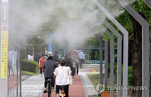 = 5일 오후 대전시 서구 둔산동 대전시청 앞에 설치된 쿨링포그 아래로 시민들이 지나가고 있다. [대전=연합뉴스]