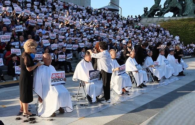 전라북도 출신 더불어민주당 의원들이 정부의 새만금 사회간접자본(SOC) 예산 삭감에 항의하며 7일 국회 본청 앞에서 삭발하고 있다. 연합뉴스