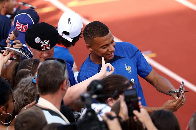 France's forward Kylian Mbappe (C) takes a selfie with fans before a training session as part of the team's preparation for upcoming UEFA Euro 2024 football tournament qualifying matches in Clairefontaine-en-Yvelines on September 5, 2023. France will play against Ireland on September 7, 2023, in the Group B of Euro 2024 qualifiers. (Photo by FRANCK FIFE / AFP)







<저작권자(c) 연합뉴스, 무단 전재-재배포 금지>