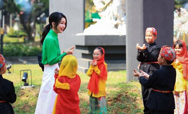 김건희 여사가 6일(현지시간) 자카르타 따만 미니 민속공원에서 인도네시아 아이들과 손하트로 인사하고 있다. [이미지출처=연합뉴스]