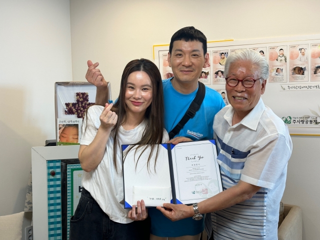 정성호 경맑음 부부에게 후원증서를 전달하는 이종락 목사.(오른쪽)