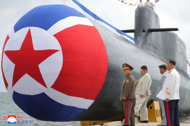 진수식 참석한 김정은 김정은 북한 국무위원장이 지난 6일 열린 전술핵공격잠수함 ‘김군옥 영웅함’ 진수식에서 신형 잠수함을 둘러보고 있다. 잠수함 진수식에서는 통상 유도탄·어뢰 등을 쏘는 잠수함의 입구를 국기 등으로 가린 채 공개하고 기술력이 드러나는 뒷부분은 공개하지 않는다.  연합뉴스