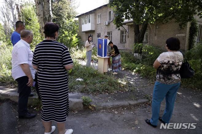[도네츠크=AP/뉴시스] 지난 6일(현지시간) 러시아 점령한 우크라이나 도네츠크 지역의 한 공터에서 주민들이 공터에서 투표를 하고 있다. 오는 10일 러시아 지방선거를 앞두고 동부 도네츠크와 루한스크, 남부 자포리자와 헤르손 등 우크라이나 내 4개 지역 점령지에서 사전투표를 실시 중이다. 2023.09.08