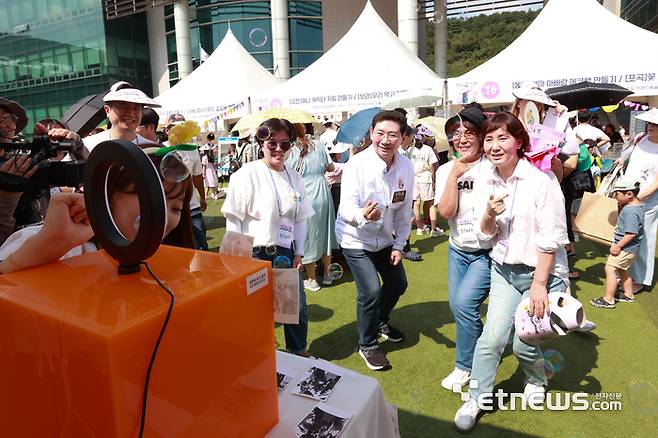 9일 이상일 용인시장이 '용인 북페스티벌' 행사장에 마련된 도서관 별 체험 부스를 방문해 도서관 직원들과 스티커 사진을 찍고 있다.