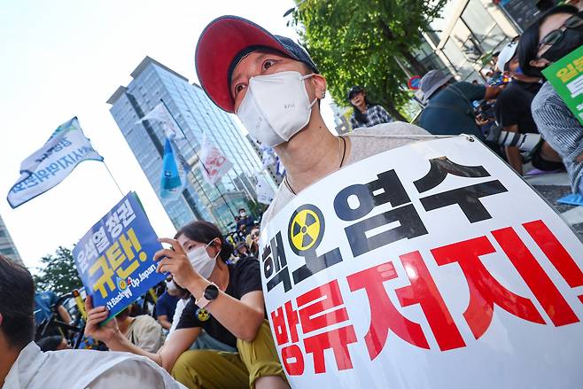 9일 오후 서울 종로구 새문안로에서 열린 후쿠시마 오염수 해양투기 중단 범국민대회에서 참가자들이 팻말을 들고 있다. [연합]