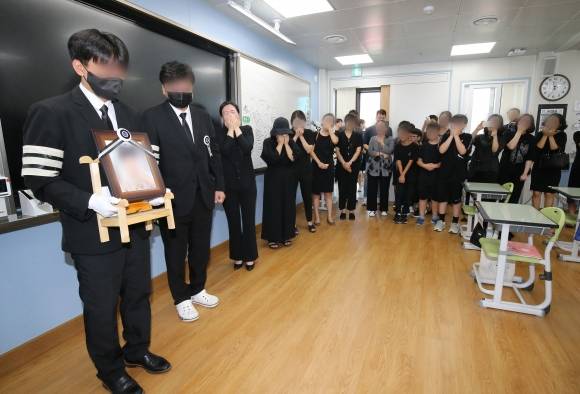 눈물바다 된 교실 - 학부모로부터 악성 민원에 시달리다 극단적 선택을 한 것으로 알려진 대전 초등학교 교사의 발인이 거행된 9일 교사가 근무했던 학교 교실에 고인의 영정이 들어서자 동료 교사와 제자들이 오열하고 있다. 2023.9.9 뉴스1