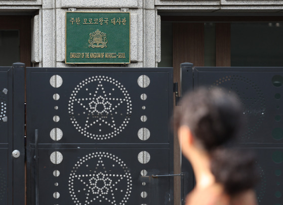 A pedestrian passes by the Moroccan Embassy in Yongsan, Seoul, on Monday. The Moroccan national flag at the embassy was lowered to mourn the death of over 2,100 people and more than 2,000 people who remain missing from last week's magnitude-6.8 earthquake that occurred 72 kilometers southwest of Marrakesh. It was the biggest earthquake to hit the North African country in 120 years. [NEWS1]