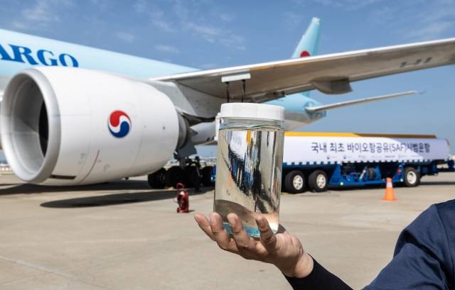 지난 5일 인천국제공항에서 열린 대한항공과 GS칼텍스의 바이오 항공유(SAF) 실증 운항기념식에서 행사 관계자가 실증 운항을 위해 급유되는 바이오 항공유를 손에 들고 있다. 대한항공 제공