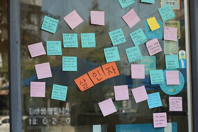 악성민원으로 세상을 뜬 대전 초등 교사와 관련 가해 학부모가 운영한다고 알려진 유성구 한 가게 앞에 비난을 담은 시민들의 쪽지가 붙어 있다. / 사진=연합뉴스