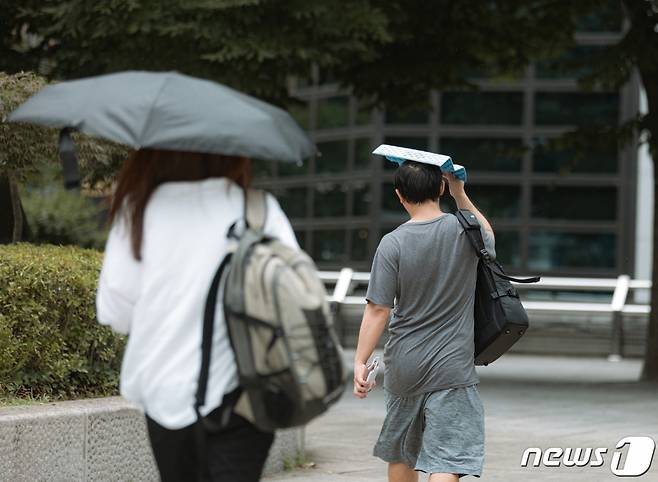 소나기가 내린 지난달 21일 서울 종로구 종각역 사거리에서 우산을 준비하지 못한 시민들이 발걸음을 재촉하고 있다./사진=뉴스1