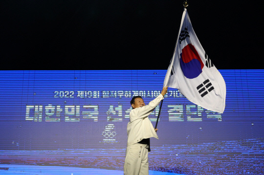 최윤 항저우 아시안게임 한국 선수단장이 12일 서울시 송파구 방이동 올림픽공원 올림픽홀에서 열린 2022 항저우 아시안게임 선수단 결단식에서 태극기를 흔들고 있다. 뉴시스