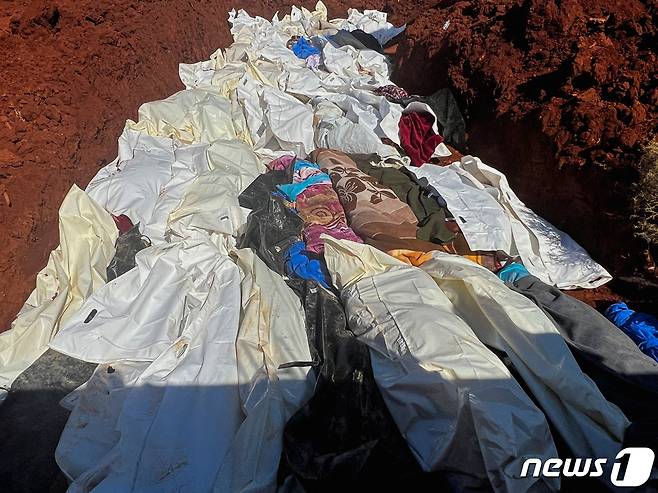 데르나시에서 시신들을 한 구덩이에 넣고 매장하고 있다. ⓒ 로이터=뉴스1 ⓒ News1 박형기 기자